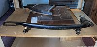 Large cast iron Ingento brand paper cutter with black handle on wooden surface.