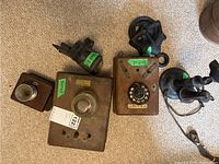 Photo of multiple wooden vintage telephone boxes with rotary dials and metal bells. Labels with dimension markings visible on each box.