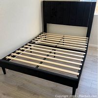 Full view of the full size bed frame with black velvet upholstery and wooden slats showing overall structure and design.