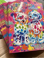 Close-up of the colorful cover showing two puppies with multi-colored paint spots and brush, title 'Paint With Water'.
