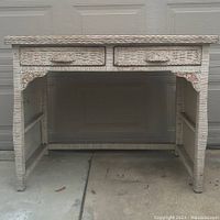 Front view of Pier 1 rattan desk showing two drawers and decorative corners