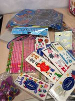 Various Creative Memories stickers including butterflies, flowers, patriotic themed, unopened in original packaging, alongside pink pencils and rulers.