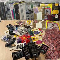 Overview of all vintage tights in original packages arranged standing and laid flat at the back. Various brands and colors visible. Hair accessories spread in front including multiple cards of clips and pins.