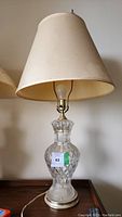 Full table lamp showing cut crystal or glass base with diamond pattern and fabric lampshade.
