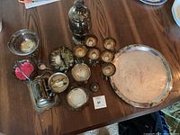 Overview of assorted silver tableware and serving items arranged on a wooden table.