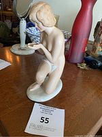 Front-side view of Wallendorf porcelain nude woman figurine on table with auction tag.