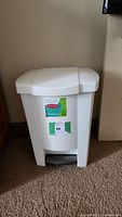 Front view of the white small step can garbage bin with lid closed, showing the Step Can brand and auction sticker.