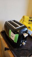 Black Sunbeam 2-slice toaster with power cord and visible controls.