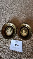 Pair of two small vintage Cameo Creation oval frames with gold-tone ornate edges and portrait prints of women.