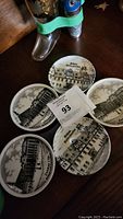 Image showing all 5 round porcelain coasters/mini plates with detailed black and white architectural scenes on each, arranged on a surface.