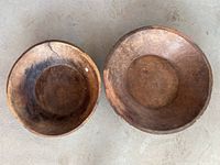 Overhead view of two wooden bowls, showing size difference and interior condition.