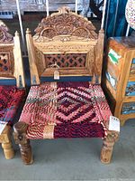 Front view of the chair showing hand carved wood backrest and colorful woven seat