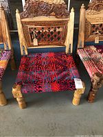 Front view shows the carved wooden backrest with floral patterns and lattice work, along with colourful woven seat.