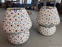 Pair of mosaic glass lamp housings shown side by side, detailing their shape and colorful mosaic pattern.