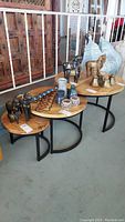 Set of three round nesting tables arranged in descending size order with decorative items placed on top.