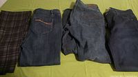 Four pairs of women's size 14 jeans, different styles and washes, laid flat showing details.