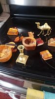 Shows full lot of brass camel figurine and wooden pieces on black surface