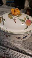 Top and side view of Evesham Yale white stoneware oven dish with fruit and leaf design and orange double-bud lid handle.