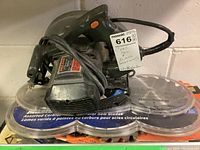 Skilsaw 7-1/4 inch circular saw on top of plastic containers holding circular saw blades, with sale tag attached to the saw handle