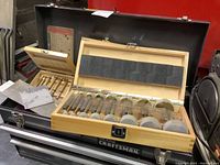 Craftsman metal tool chest with open lid showing wooden boxes of drill bits inside