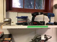 Overview of all items including drills, hex keys set, and pencil sharpener on a white shelf under window.