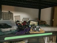Shelf with fishing reels, boxes, and tackle boxes showing equipment and packaging
