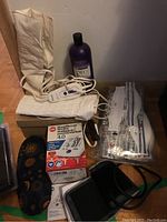 Photo showing electric heating pads, blood pressure monitor box, slippers, shampoo bottle, and some face masks.