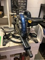 Mastercraft 10-inch sliding compound miter saw showing front angle with blade guard in place and dust collection port visible.