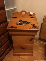 Full view of one wooden potato bin showing front panel, hinged lid with loon design, heart-shaped cutout on back panel.