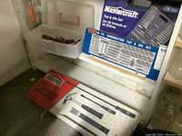 Photo shows Mastercraft 76-piece tap and die set boxed alongside a boxed set of pry bars and hammer labeled 'Jormate'