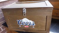 Wooden Coors Banquet cooler showing front panel with logo and metal latch closure
