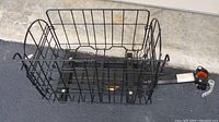 Full view of the black metal wire bicycle basket showing the rectangular storage compartment and attached mounting arm.