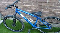 Blue mountain bike, side view showing blue frame, padded black seat, and rear tire installed. Front wheel missing.