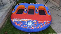 Top down view of the 3-person Maelstrom towable tube with blue and orange coloring, showing three seating compartments with black mesh areas and many grips.
