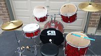Front view of complete drum kit showing shells, cymbals, stands and throne