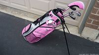 Pink and grey Callaway XJ golf bag standing with clubs inside.