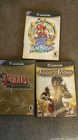 Front covers of the three GameCube games showing Super Mario Sunshine, Prince of Persia The Two Thrones, and Zelda The Wind Waker cases