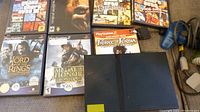 Photo of 7 PlayStation 2 games lined up with some partially visible including Grand Theft Auto series and others.