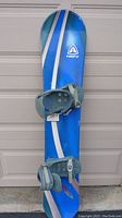 Top side view of blue Firefly snowboard with grey bindings attached showing board design and condition.