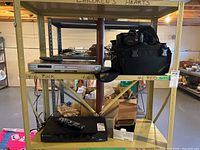 Three shelf rack showing Panasonic DVD/CD player and Chinon camera on upper shelves.