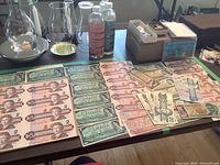 Mixed collection of Canadian and Mexican paper currency spread out on table showing multiple denominations of Canadian bills including two dollar, five dollar Laurier, twenty dollar, fifty dollar bill plus assorted Mexican bills in various colors and sizes.