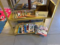 Two shelves in basement with stacks of Mad and Circus magazines and a shoebox