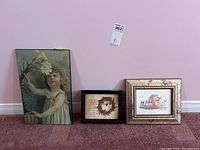 Wide shot showing all three framed pieces against pink wall and carpet
