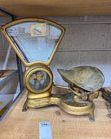 Left side profile showing gold-tone scale and removable bowl on wooden shelf