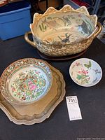 Photo showing all three pottery items including the large oval bowl with handles, medium round floral bowl, and small round butterfly bowl arranged side by side on a table.