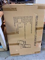 Cardboard box with product specifications and sketch of reclining gravity lounge chair. Brand Sarasota Breeze, SKU 1217610-2, blue color, 1 piece, 17.6 lbs net weight, 15.4 lbs case weight, made in China.