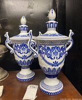 Pair of blue and white ceramic Bombay vases with lids, larger vase in the background