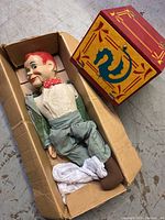 Top-down view of puppet and magic box in cardboard box