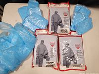 Loosely stacked ten blue splash-proof disposable plastic aprons, showing color and quantity.