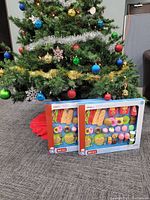 Two boxed Chef play sets with visible toy food pieces in front of a Christmas tree.
